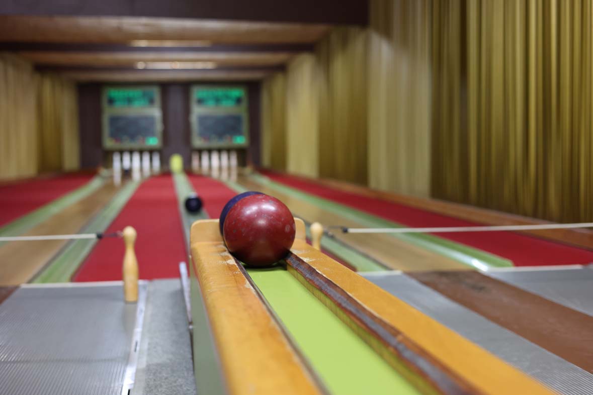 Bowling alley with a red carpet and balls in the middle