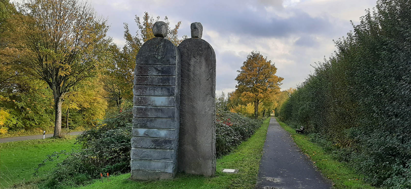 Two stone sculptures on the left of the bike path